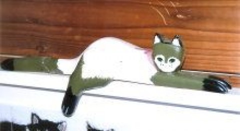 梁に乗る木彫りの猫